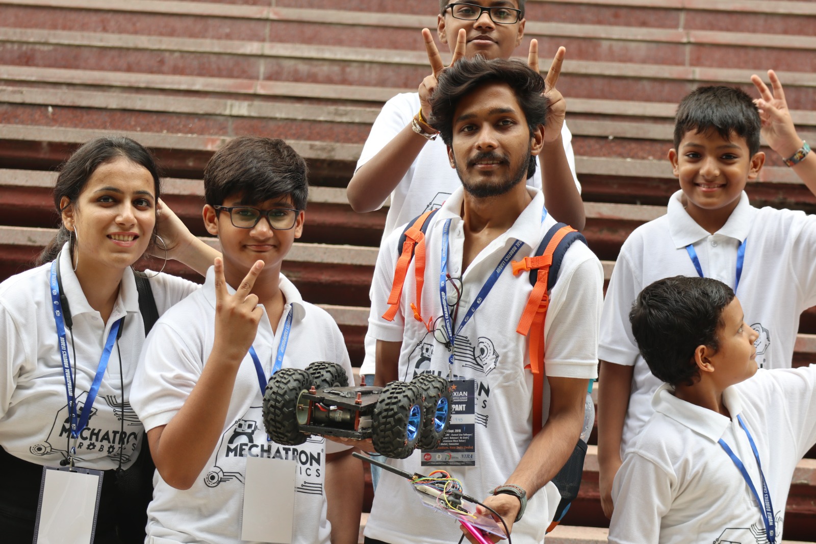 Mechatron students holding their competition robot at a robotics championship