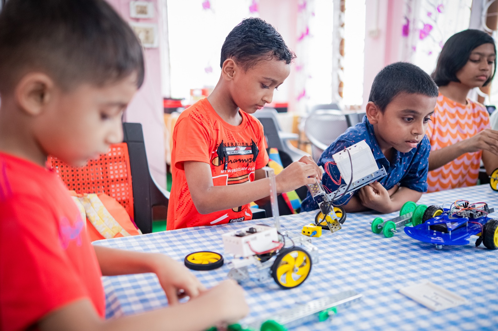 Young Mechatron students building robot cars from Mechatron kits